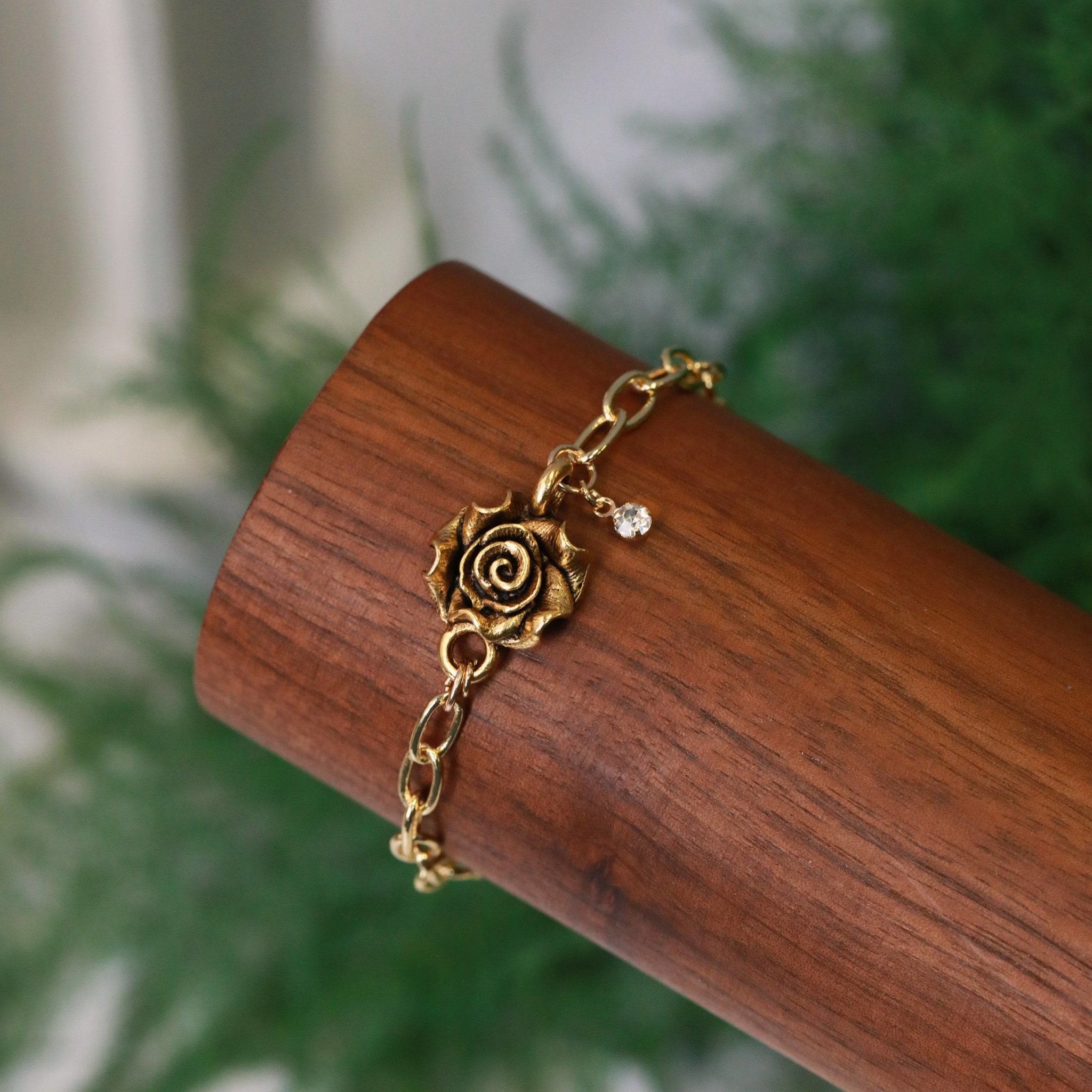 gold rose connector bracelet with crystal charm on gold plated chain closeup