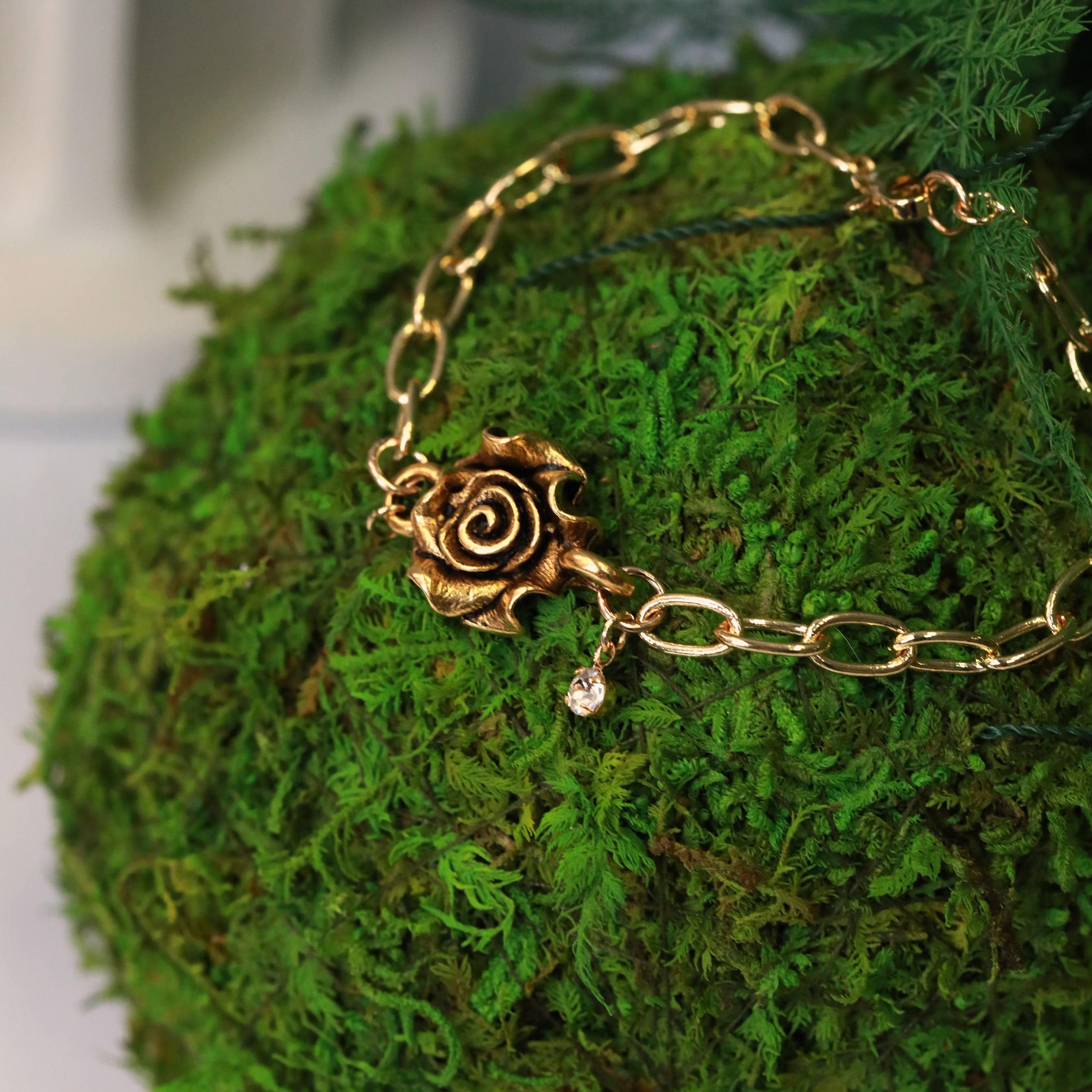 gold rose connector bracelet with crystal charm on gold plated chain grass image